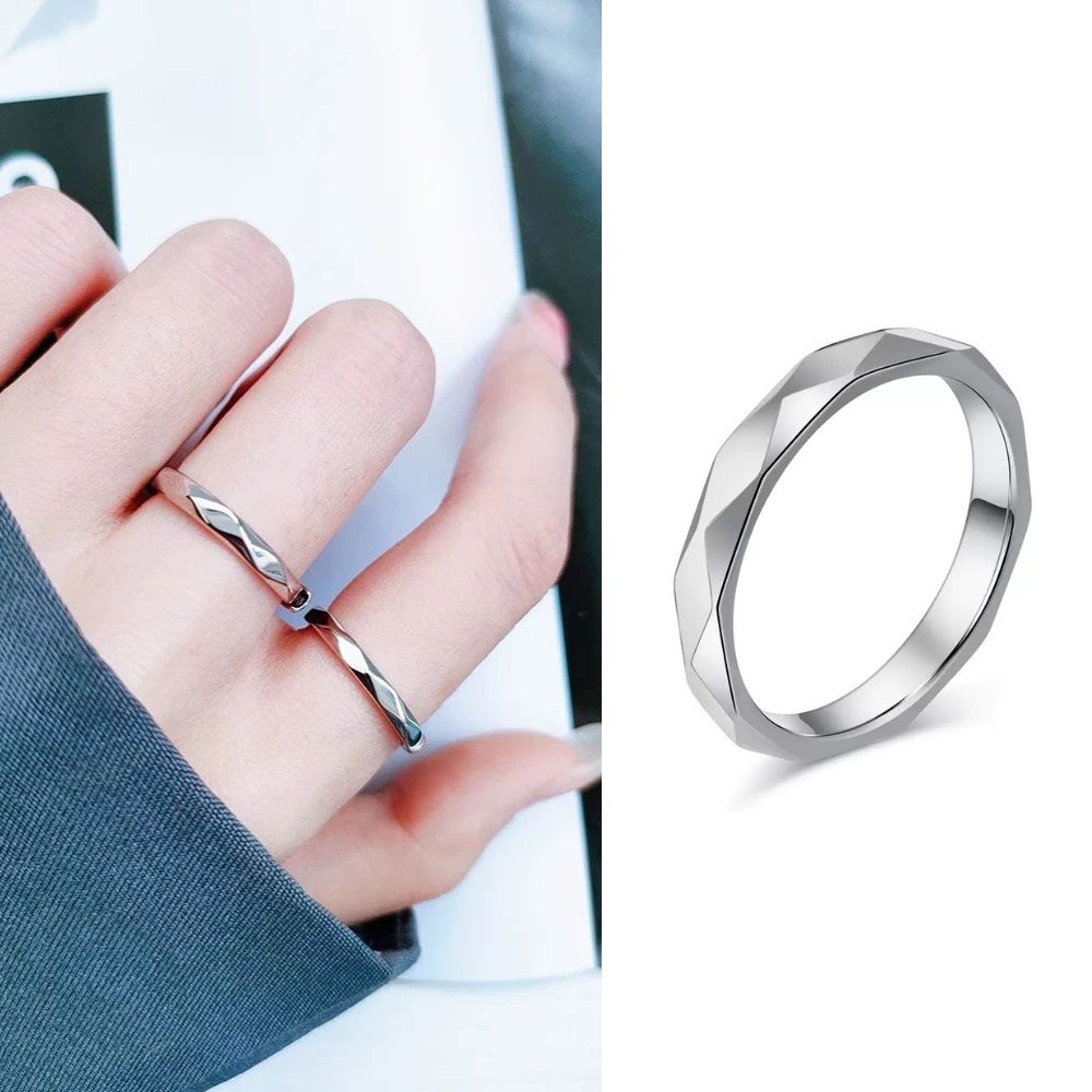 Silver ring on a finger and another silver ring on a white background