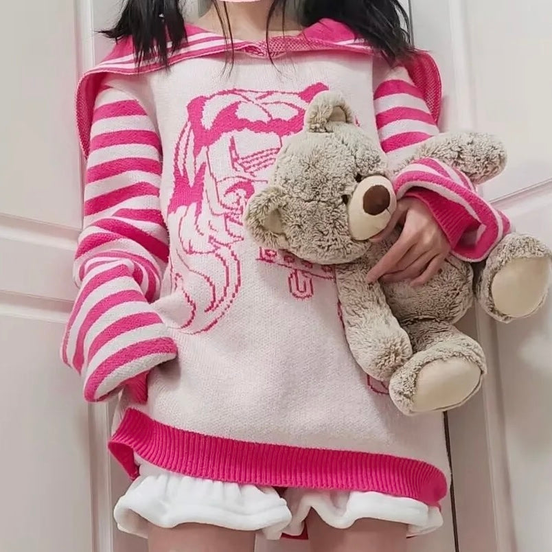 Person wearing a pink and white striped sweater with a teddy bear plush toy