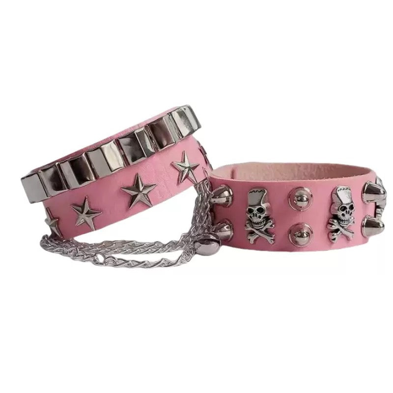 Pink gothic skull leather bracelets with silver studs and chain on a white background