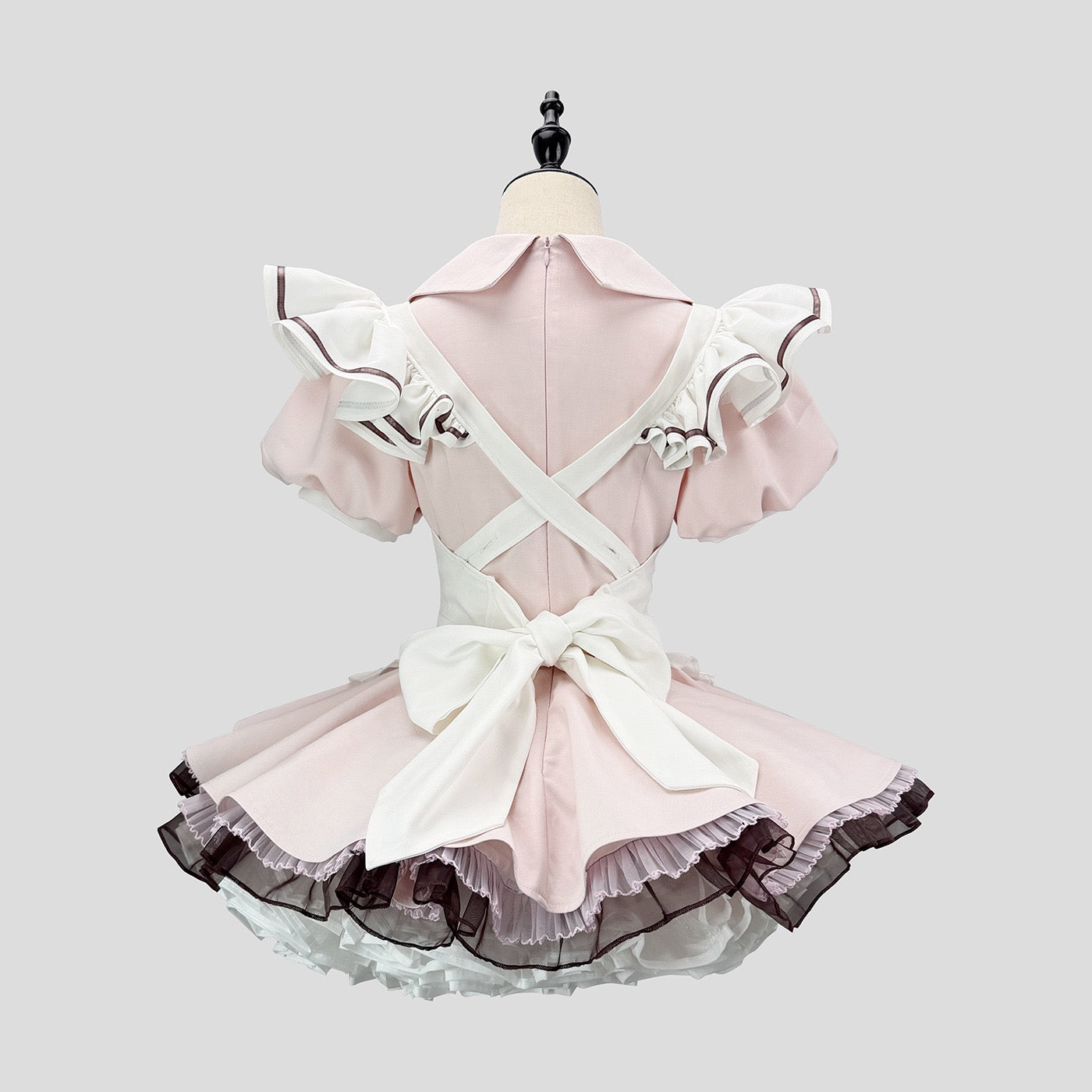 Pink and white dress on a mannequin against a light gray background