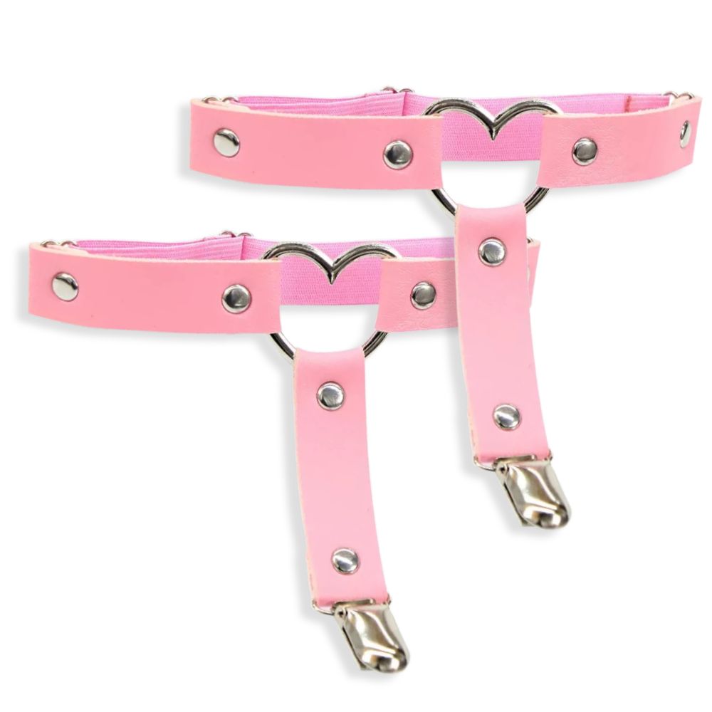 Pink leg garters with metal heart designs and clips on a white background