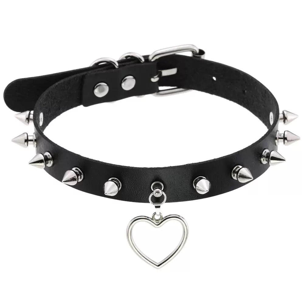 Black leather choker with silver spikes and a heart-shaped pendant on a white background