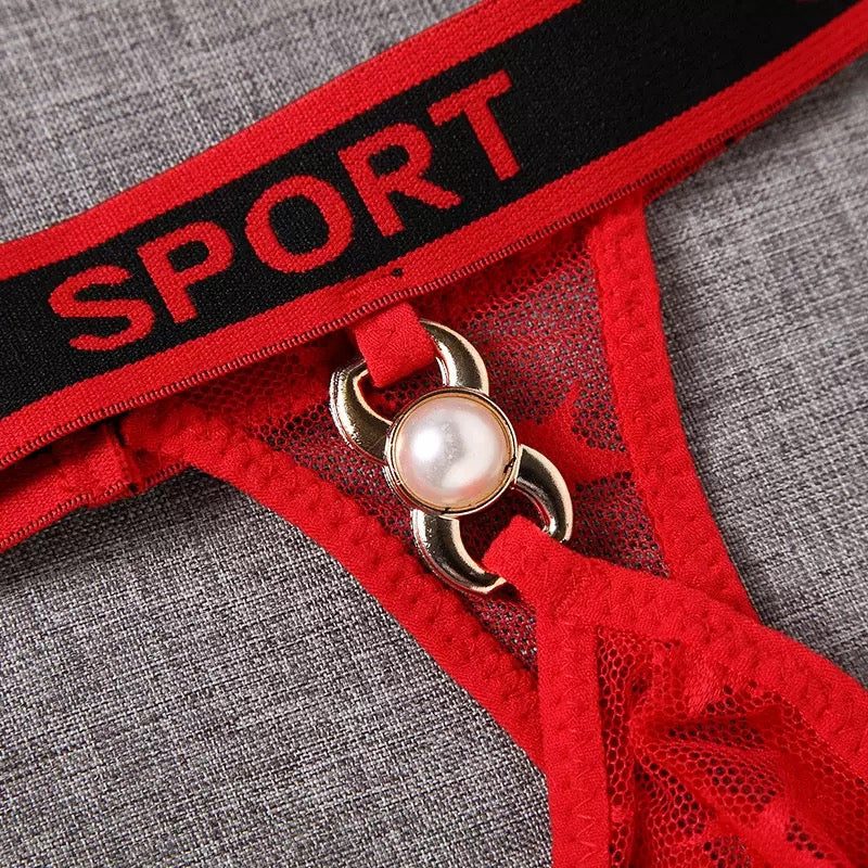 Red lace lingerie with a gold clasp and 'SPORT' waistband on a gray background