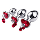 Metallic anal plugs with red gemstones on a white background