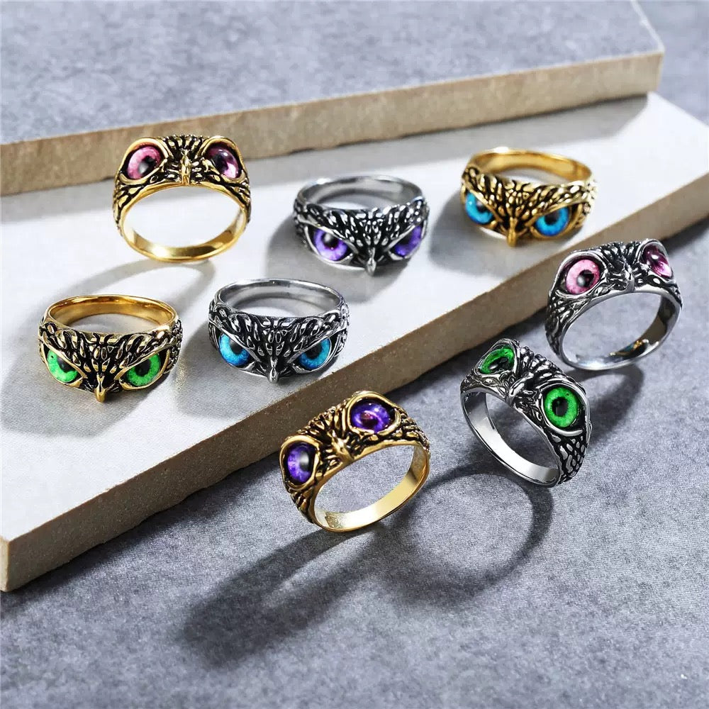 Set of colorful owl-themed rings on a gray surface