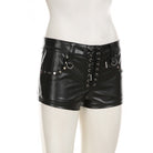 Black leather shorts with lace-up front and embellishments on a white background