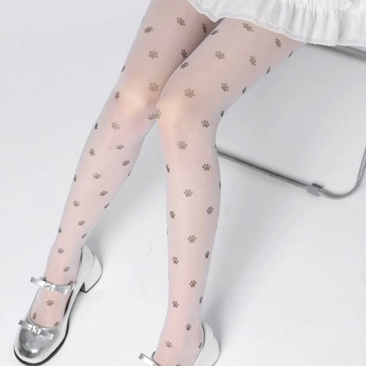 Sheer tights with paw print pattern worn by a person sitting on a chair.