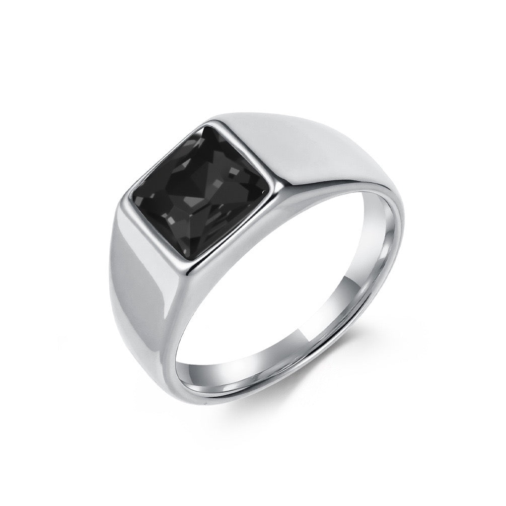 Silver ring with a black gemstone on a white background