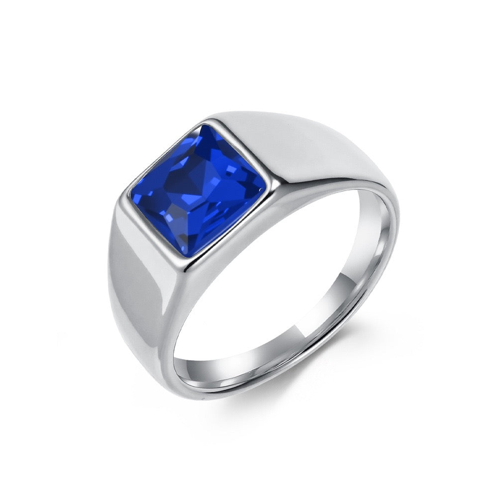 Silver ring with a blue gemstone on a white background