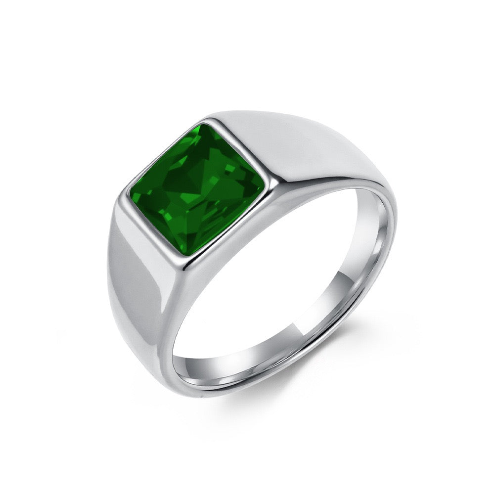 Silver ring with a green gemstone on a white background
