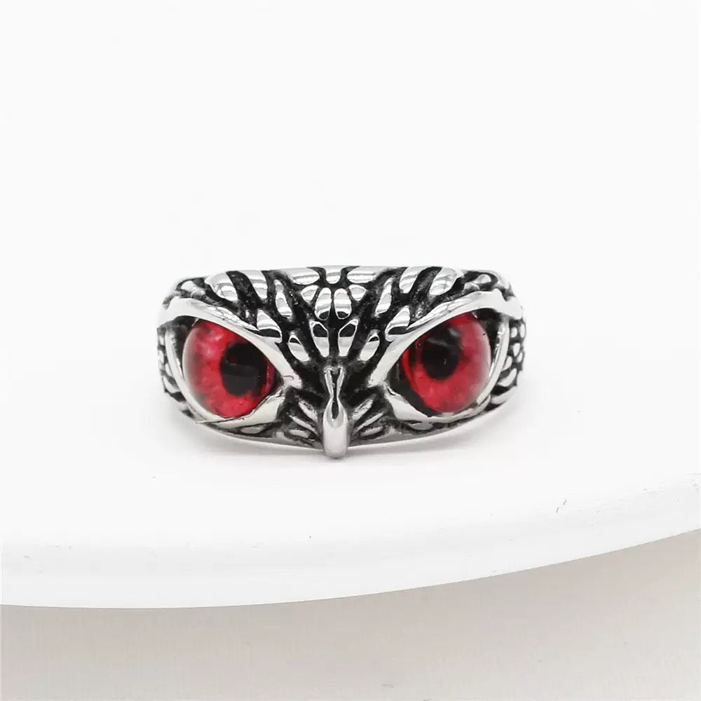 Silver owl ring with red eyes on a white background