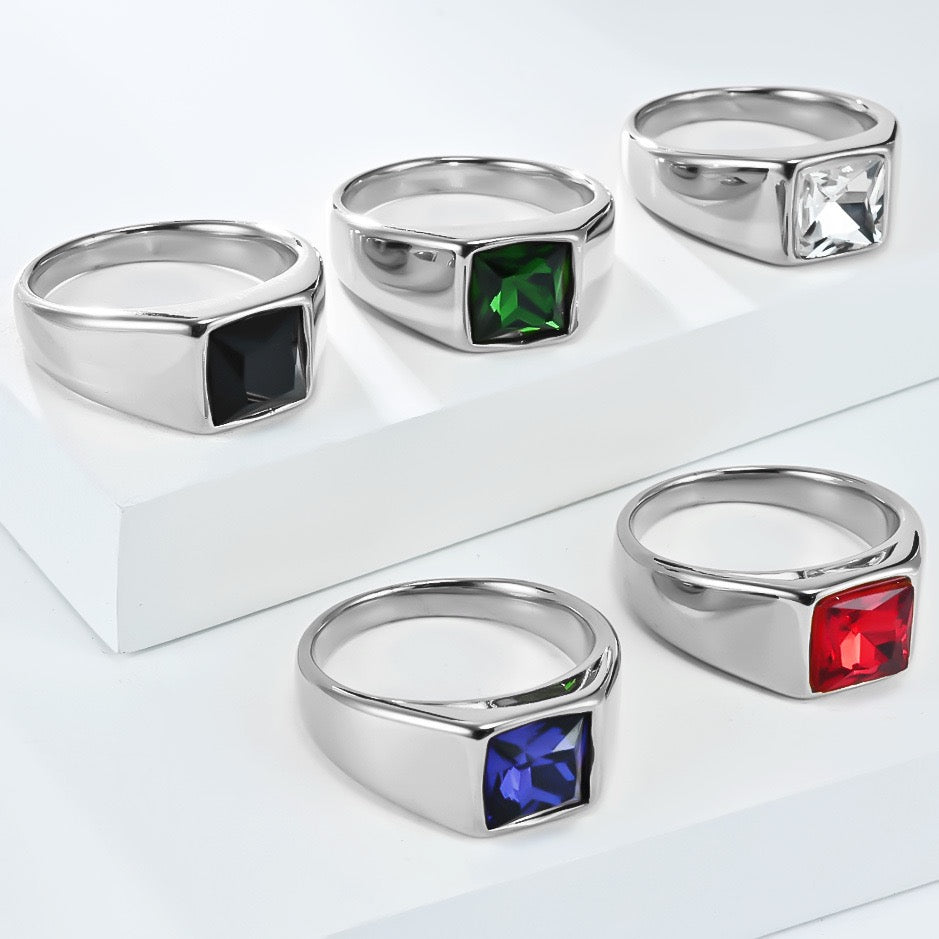 Set of silver rings with colored gemstones on a white background