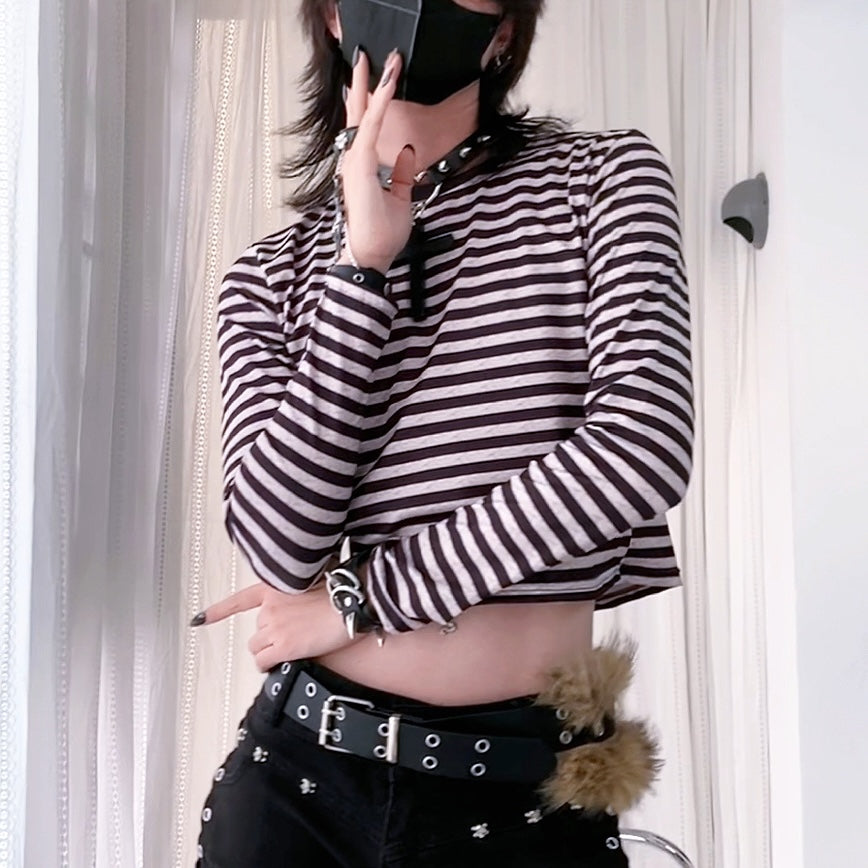 Femboy wearing a black and white striped long-sleeve top with a belt and fur accessory.
