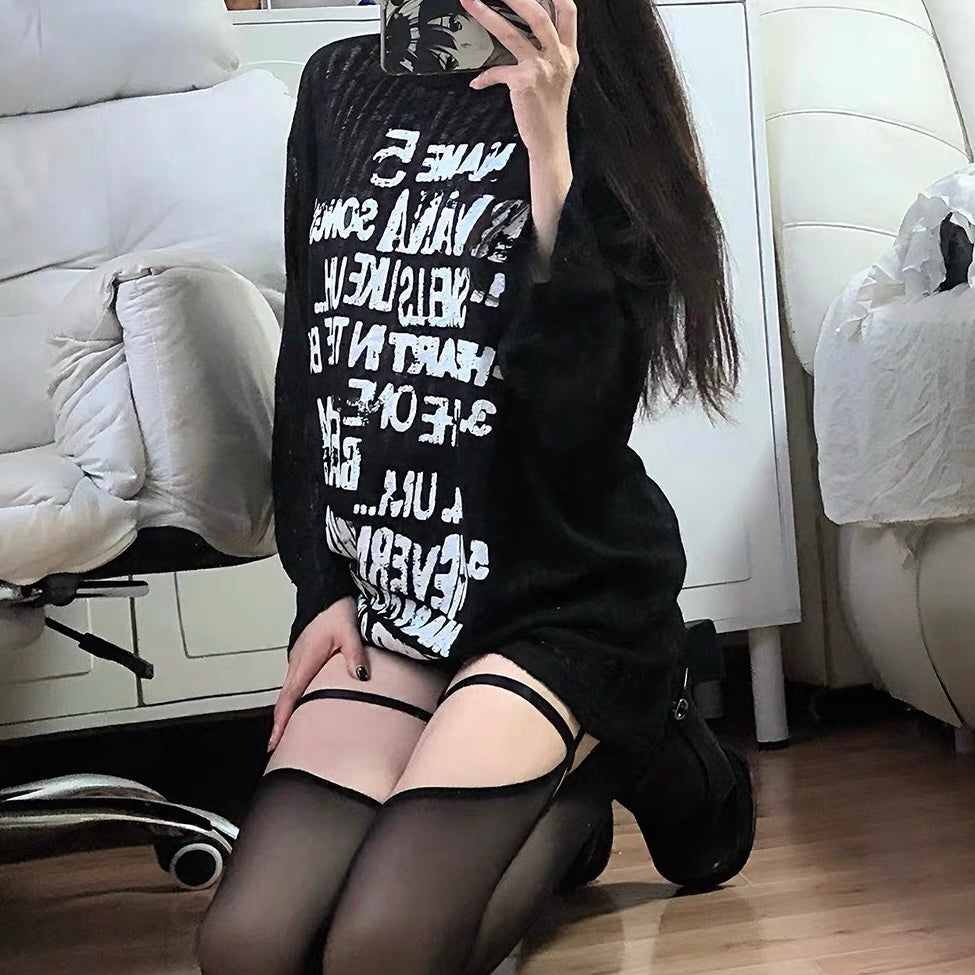 Black top with sheer sleeves and black bows on a white background