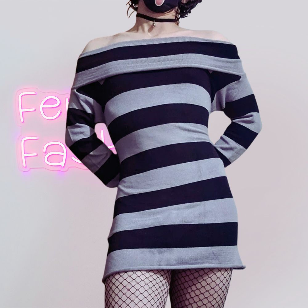 Person wearing a black and gray striped dress with a white background