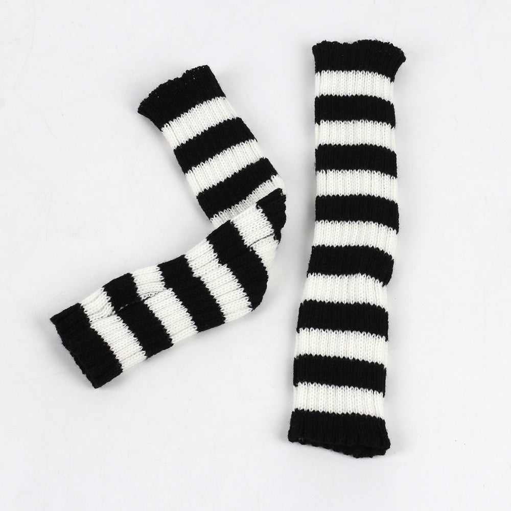 Black and white striped arm warmers on a light gray background