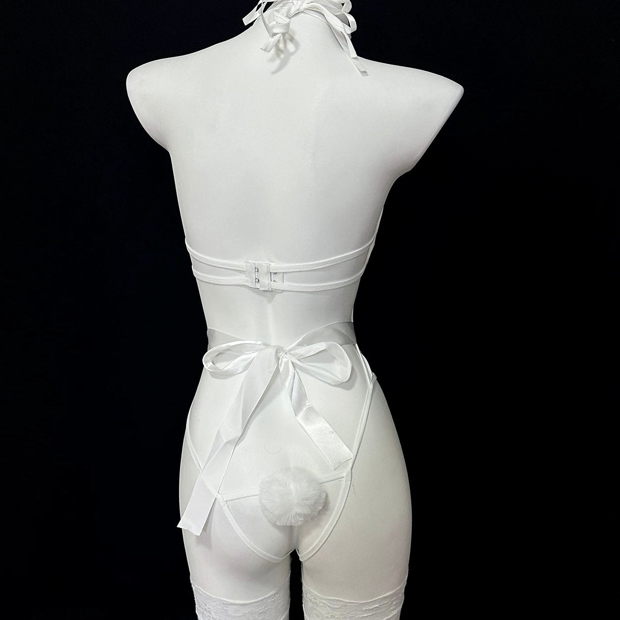 White lingerie set on a mannequin against a black background