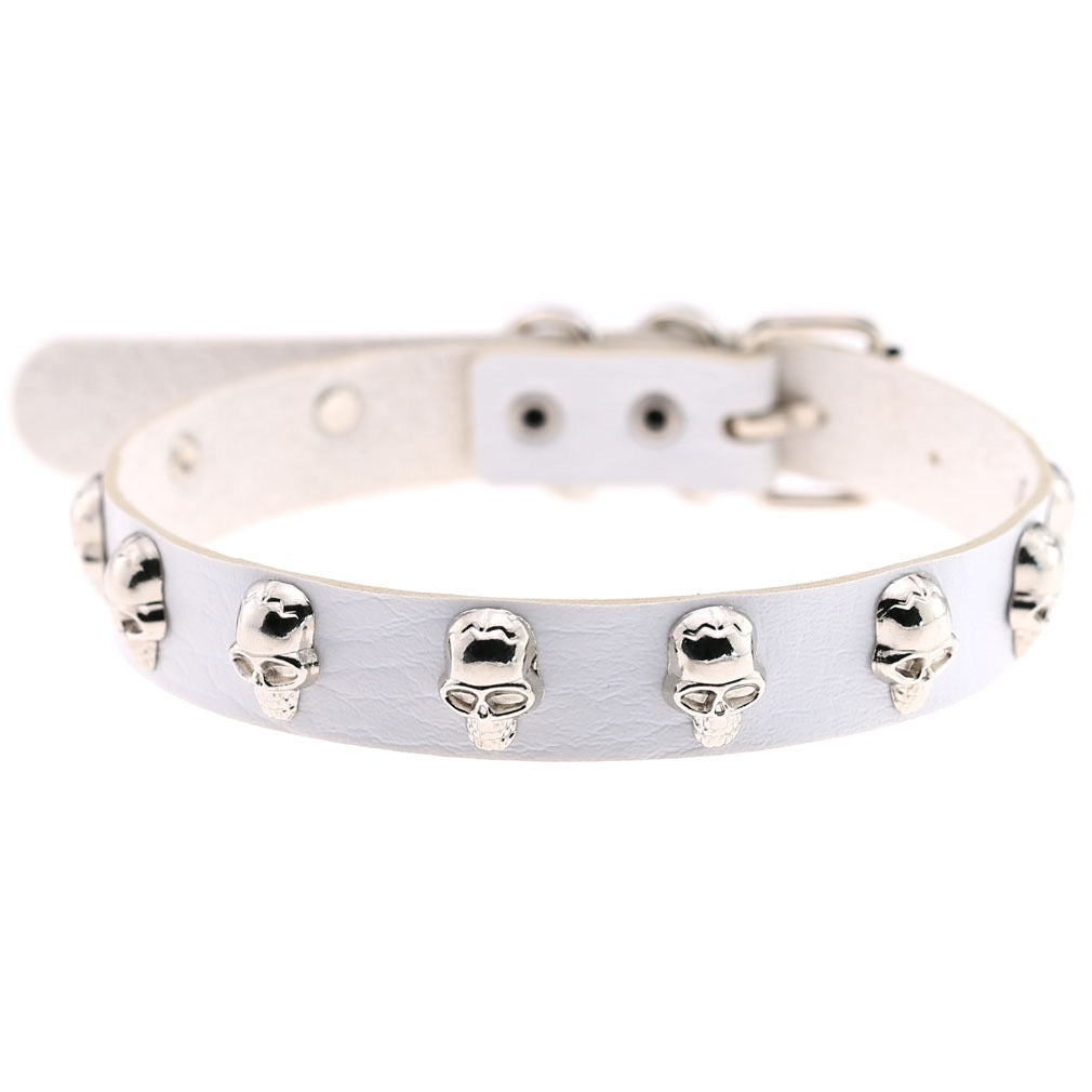 A white faux leather collar decorated with multiple silver skull studs, shown against a plain white background.