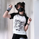 Person wearing a white t-shirt with black graphics and text, black shorts, and a black mask, posing with arms raised.