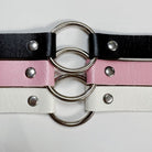 Three leather chokers with metal rings on a white background