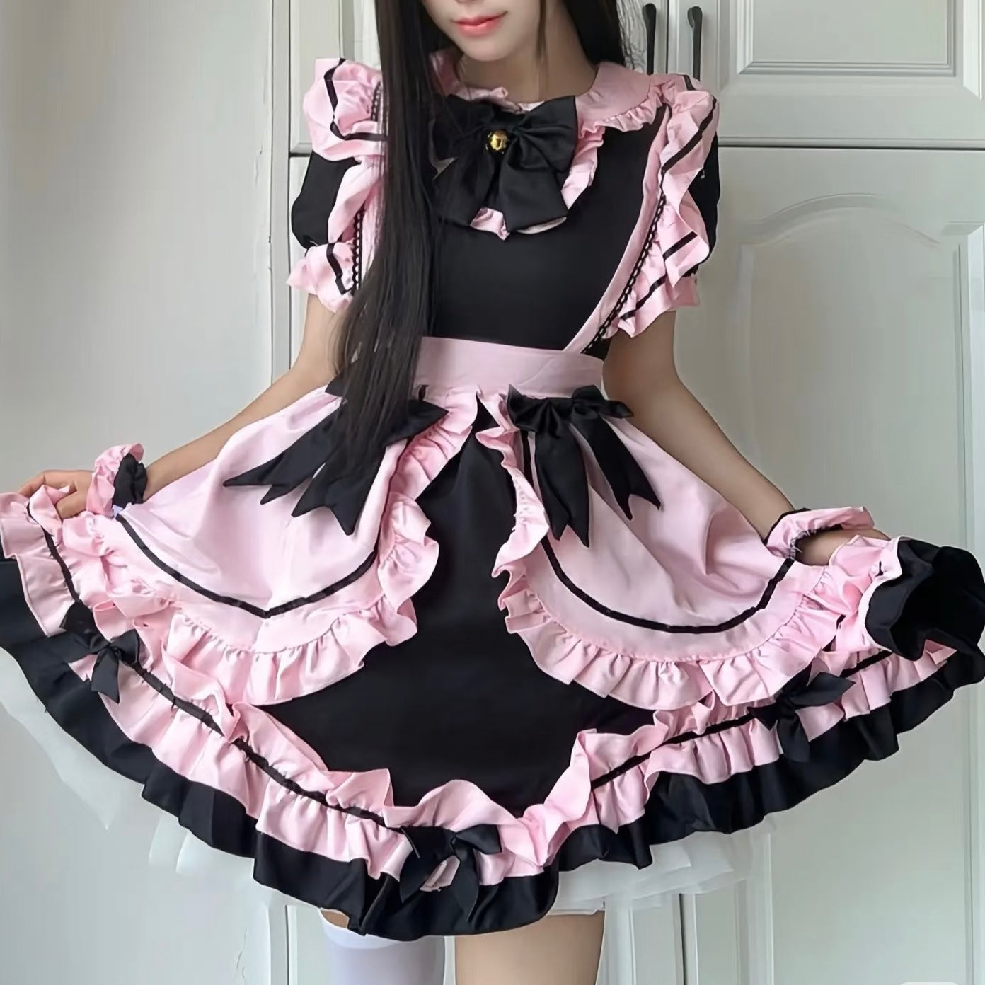 Person wearing a black and pink maid outfit taking a mirror selfie.