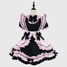 Black and pink dress with ruffles on a mannequin against a white background