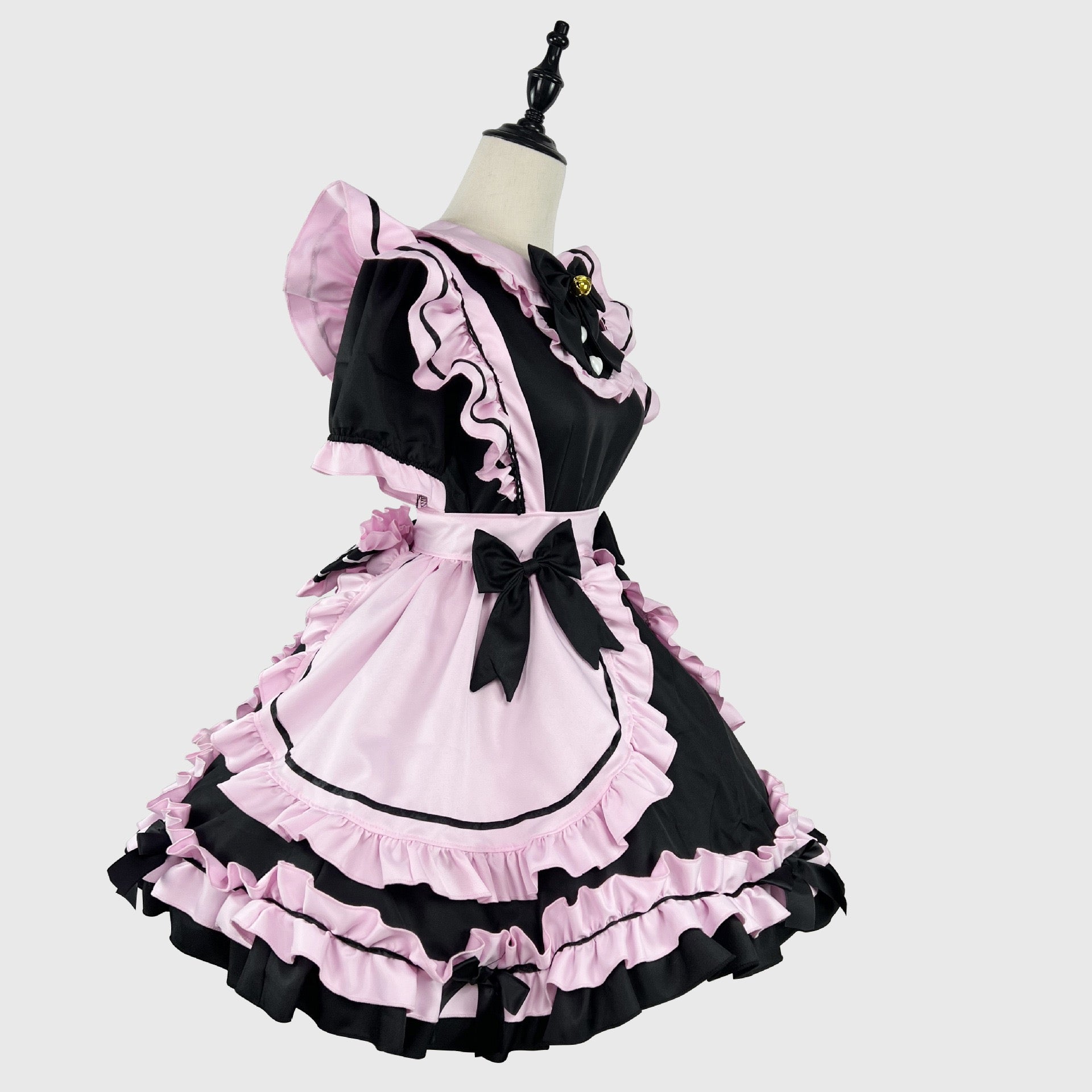 Black and pink dress with ruffles on a mannequin against a white background