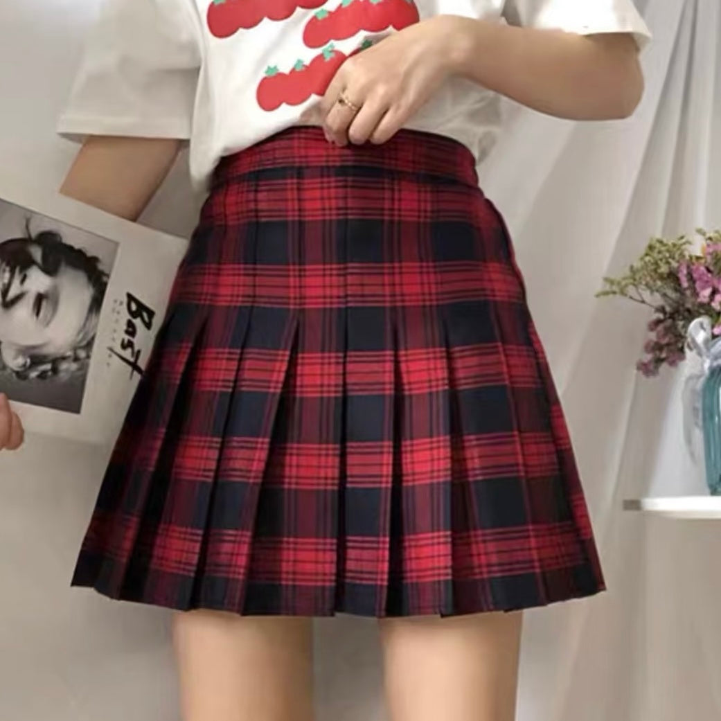 Person wearing a red and black plaid skirt with a white shirt.