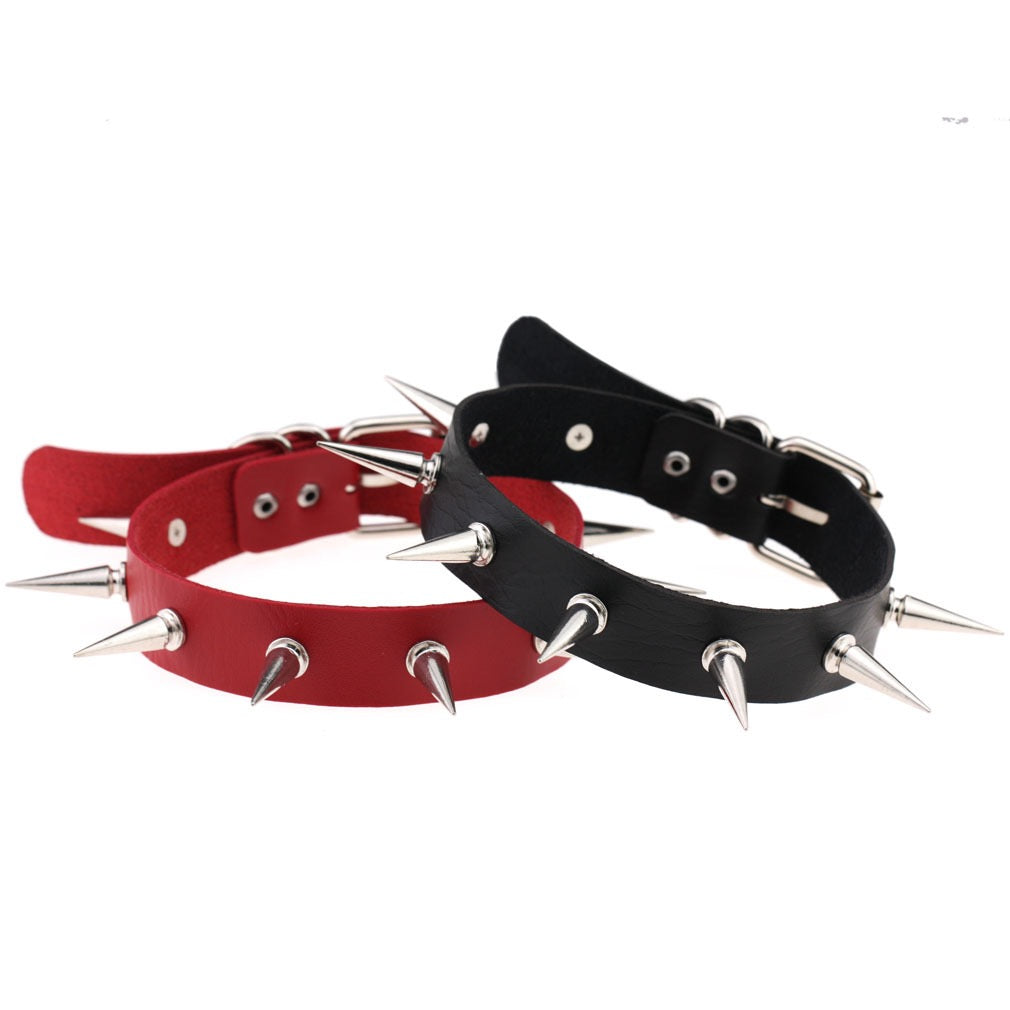Red and black spiked leather chokers on a white background