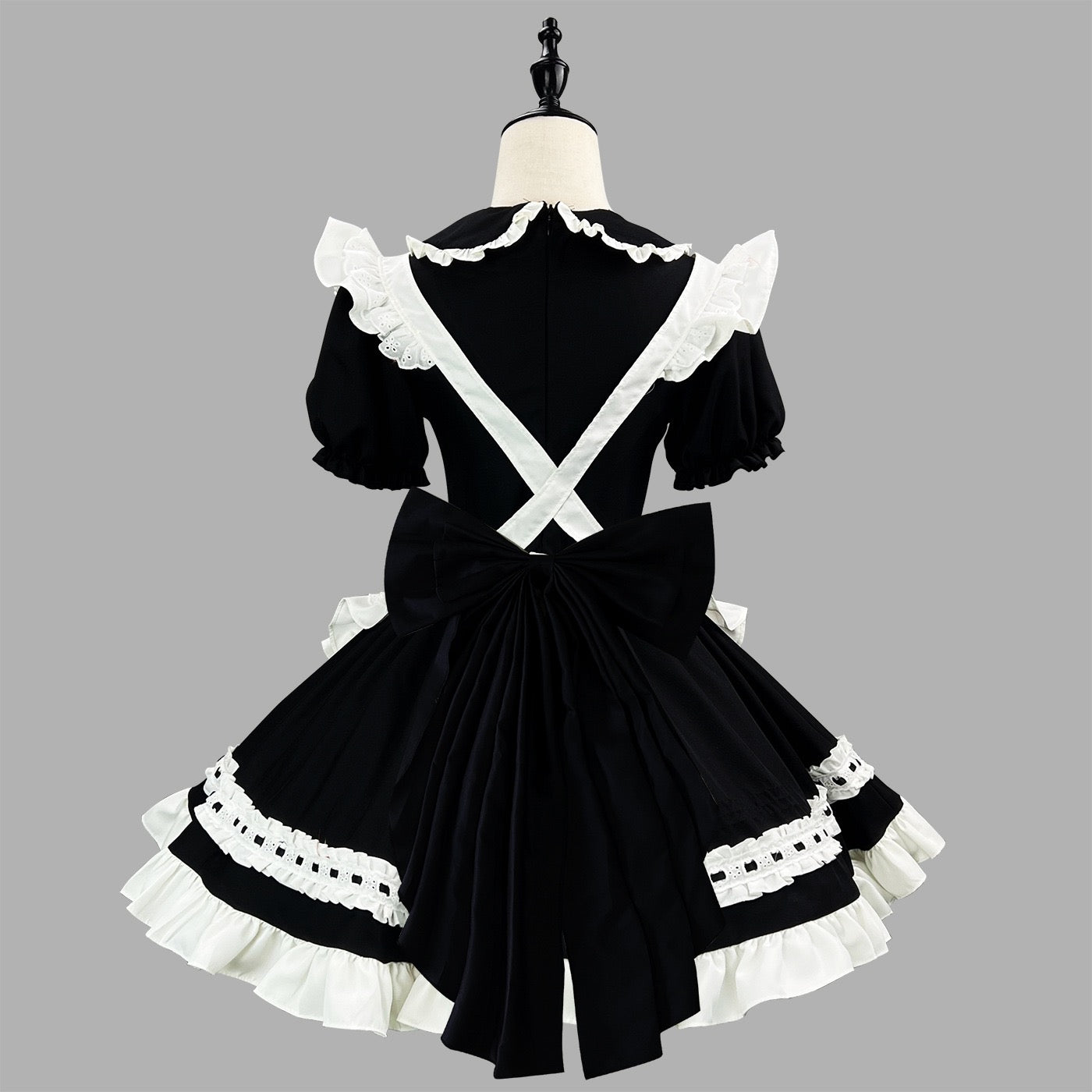 Black and white maid costume on a mannequin against a gray background