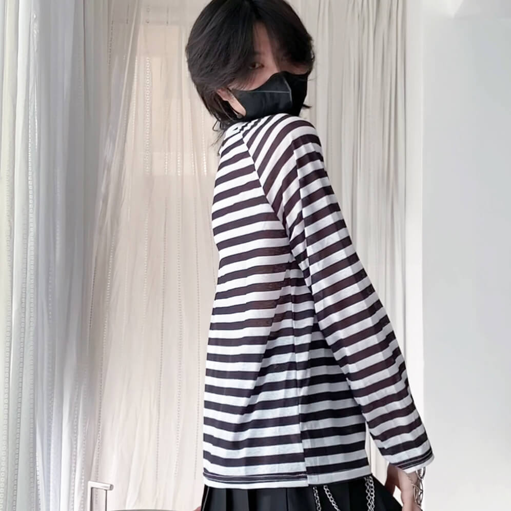 Person wearing a black and white striped shirt with a blurred background