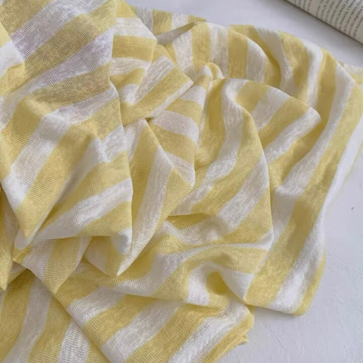 Yellow and white striped fabric on a white background