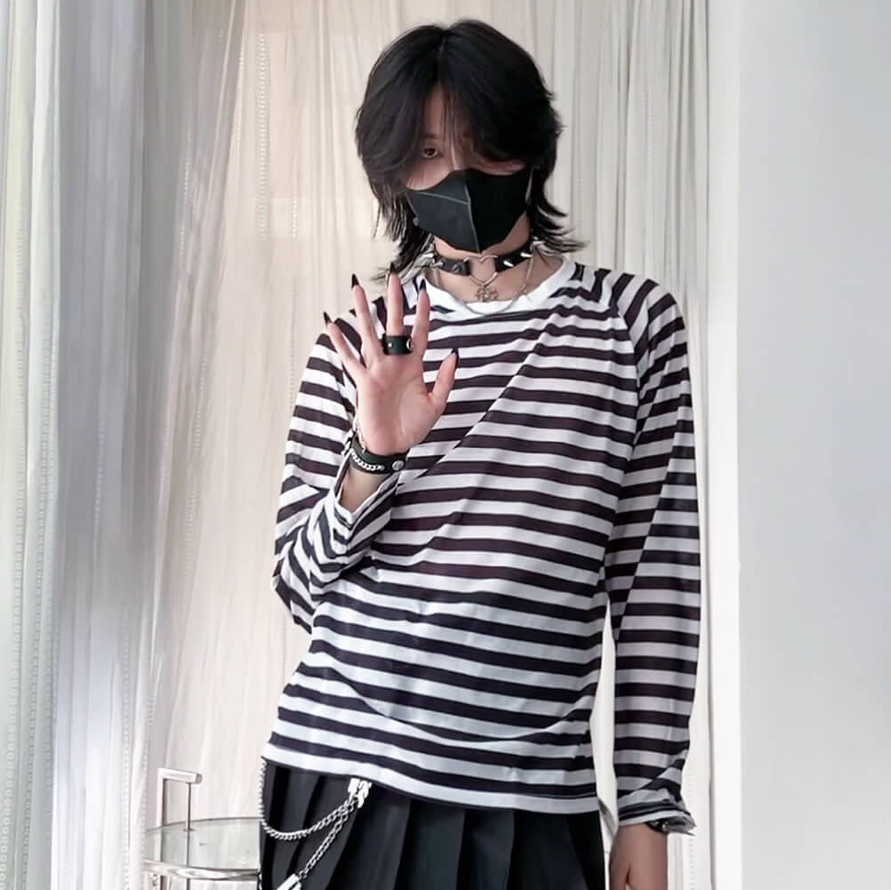 Person wearing a black and white striped shirt with a plain background