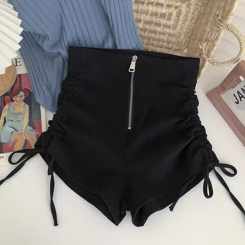 Black high-waisted shorts with a zipper on a white surface