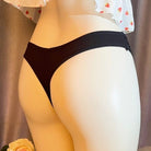 Black thong worn by a mannequin against a neutral background