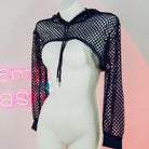 Mannequin wearing a black fishnet top with a neon sign in the background
