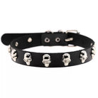 A black leather collar decorated with multiple silver skull studs, displayed against a plain white background.