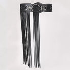 Black leather belt with tassel on a light gray background