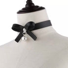 Black choker with a bow and bell charm on a mannequin.