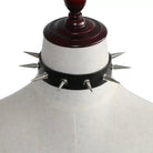 Black leather choker with spikes on a mannequin against a white background