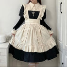 Person wearing a black and white dress with ruffled details in a room.