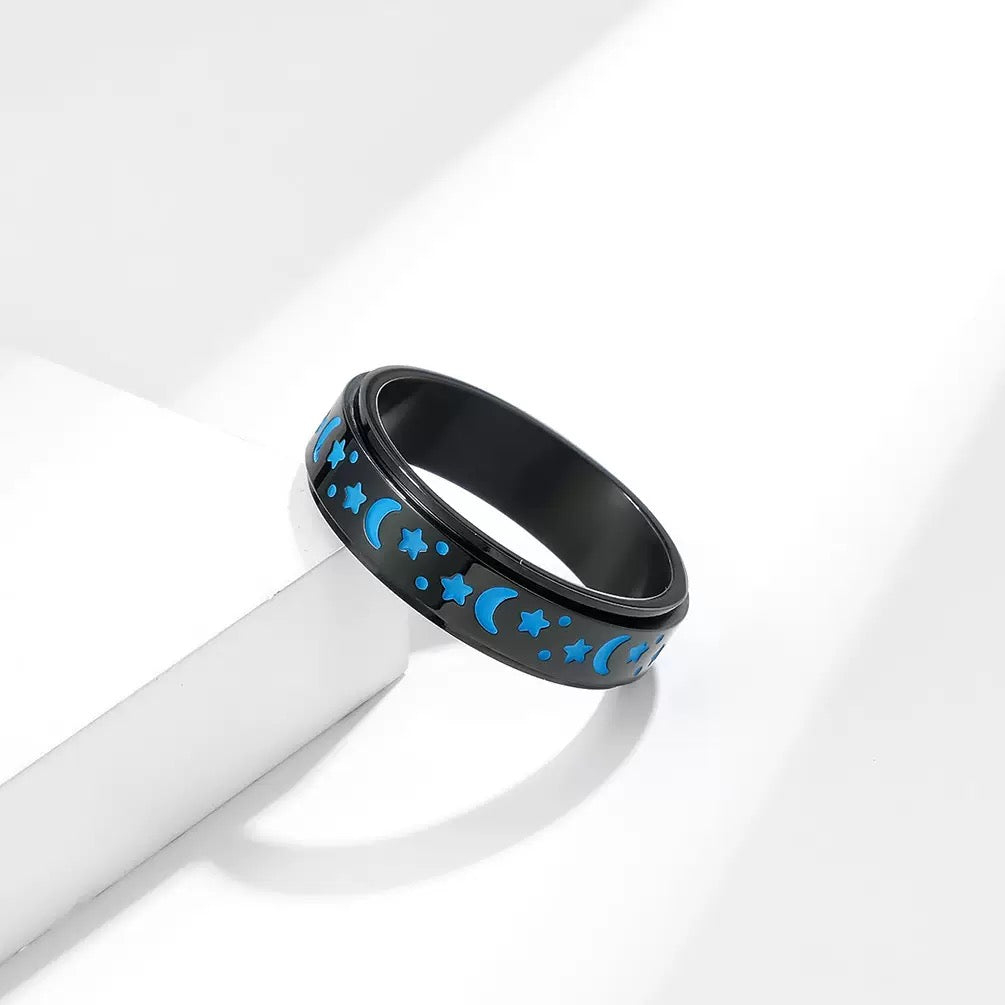 Black ring with blue star and moon pattern on a white background