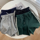 Four pairs of shorts in different colors on a round white table.