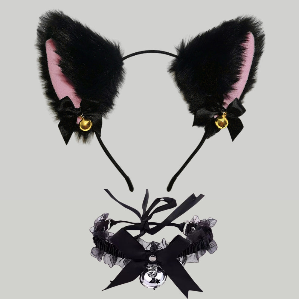 Black faux fur cat ears headband with pink inner lining, black bows, small gold bells, and a matching black ruffled collar with a large black bow and skull charm, shown on a light gray background.