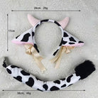 Cow-print plush headband with pink horns, cream ribbons, and a matching tail accessory laid on a light textured fabric background, with measurement lines and text showing dimensions and weight.
