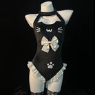 A black cat-themed halter bodysuit with white ruffles, a large white bow with a small bell, and white cat face and paw print graphics, displayed on a white mannequin torso against a black background.