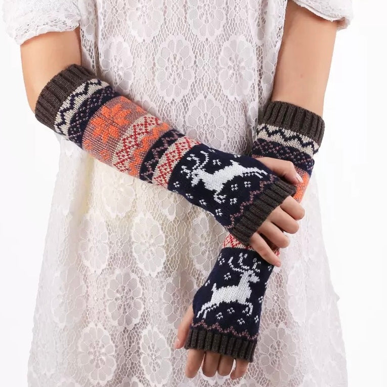 Knitted arm warmers with deer pattern worn by a person on a white lace background