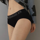 Person wearing black underwear with visible branding against a neutral background