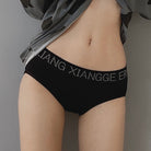 Person wearing black underwear with visible branding against a gray background
