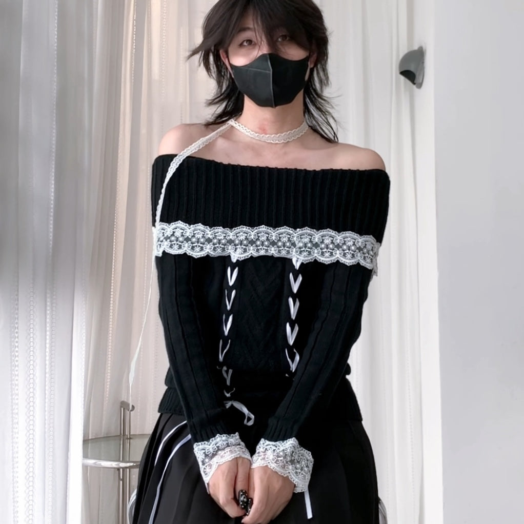 A femboy wearing a black off-the-shoulder ribbed knit top with white lace trim across the chest and cuffs, plus white lace-up detailing down the front, paired with a black skirt and a black face mask.
